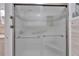 Tiled shower with glass doors and grab bars offering both safety and accessibility at 1710 New Bedford Dr, Sun City Center, FL 33573