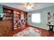 Cozy bedroom with built-in bookshelves, hardwood floors, and a ceiling fan at 1710 New Bedford Dr, Sun City Center, FL 33573