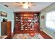 Bedroom with wall of built-in shelves, hardwood floors, and a ceiling fan at 1710 New Bedford Dr, Sun City Center, FL 33573