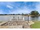 Waterfront dock with white railings, brick pavers, and scenic views of the lake and surrounding homes at 1710 New Bedford Dr, Sun City Center, FL 33573