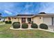 This inviting home is framed by lush landscaping, a brick walkway, and a bright red front door at 1710 New Bedford Dr, Sun City Center, FL 33573