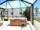 Covered hot tub on the screened patio, providing a relaxing spot with views of the lush backyard at 1710 New Bedford Dr, Sun City Center, FL 33573