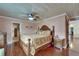 Spacious main bedroom featuring hardwood floors, a ceiling fan, and a decorative headboard at 1710 New Bedford Dr, Sun City Center, FL 33573