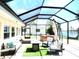 Screened patio with stylish seating, fire pit, and lake view offers an ideal outdoor living space at 1710 New Bedford Dr, Sun City Center, FL 33573