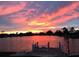 Beautiful water view from the house featuring a dock and a fiery sunset backdrop at 1710 New Bedford Dr, Sun City Center, FL 33573
