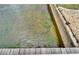 Clear waterfront view from the dock showing the water, greenery, and rock details at 1710 New Bedford Dr, Sun City Center, FL 33573