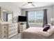 Well-lit bedroom with stylish dressers, a large window, and serene view at 18414 Malinche Loop, Spring Hill, FL 34610