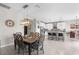 Open concept dining area with a modern light fixture, adjacent to the kitchen with breakfast bar at 18414 Malinche Loop, Spring Hill, FL 34610