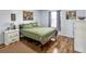 Cozy bedroom with hardwood floors, neutral walls, and a comfy green quilt at 1848 Trillium Blvd, Brooksville, FL 34604