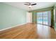 Bedroom featuring wood floors, a ceiling fan, neutral walls, and sliding glass doors to the pool at 19 Seedling Dr, Safety Harbor, FL 34695