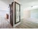 Open-concept living room with light wood flooring, a sliding barn door, and a decorative mirror at 19 Seedling Dr, Safety Harbor, FL 34695