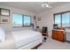 Bright bedroom featuring two large windows, a ceiling fan, and minimalist décor with carpeted floors at 2 Adalia Ave # 601, Tampa, FL 33606