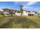 Lovely home featuring a stucco exterior, tile roof, lush lawn, and a backyard deck at 2005 N Pointe Alexis Dr, Tarpon Springs, FL 34689