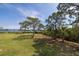 Expansive backyard with mature trees and serene water views; ideal for outdoor activities at 2005 N Pointe Alexis Dr, Tarpon Springs, FL 34689