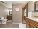 Open bathroom with wooden vanities, tile flooring, walk-in shower, toilet, and decorative artwork at 2005 N Pointe Alexis Dr, Tarpon Springs, FL 34689