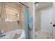 Bathroom featuring a bathtub with shower, tiled walls, and a window at 2005 N Pointe Alexis Dr, Tarpon Springs, FL 34689