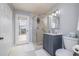 Clean bathroom with a shower, blue vanity, and access to the outdoor pool area at 2005 N Pointe Alexis Dr, Tarpon Springs, FL 34689