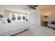 Spacious bedroom featuring a ceiling fan, large windows with curtains, and white carpet flooring at 2005 N Pointe Alexis Dr, Tarpon Springs, FL 34689