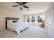 Spacious bedroom with a ceiling fan, large windows with curtains, and white carpet and a wooden bed frame at 2005 N Pointe Alexis Dr, Tarpon Springs, FL 34689