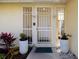 Close up of Front door featuring decorative security screen and potted plants at 2005 N Pointe Alexis Dr, Tarpon Springs, FL 34689