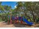 Vibrant community playground with slide and climbing area is surrounded by mature trees for shady fun at 2005 N Pointe Alexis Dr, Tarpon Springs, FL 34689