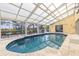 Inviting enclosed pool area featuring a tile pool, and relaxing deck area with comfortable seating at 2005 N Pointe Alexis Dr, Tarpon Springs, FL 34689