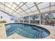 Enclosed pool area with a spacious deck, comfortable seating, and serene water views at 2005 N Pointe Alexis Dr, Tarpon Springs, FL 34689