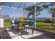 Relaxing screened porch with outdoor dining set, perfect for enjoying water views at 2005 N Pointe Alexis Dr, Tarpon Springs, FL 34689