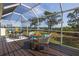 Inviting screened porch with wicker seating offers a tranquil space with waterfront views at 2005 N Pointe Alexis Dr, Tarpon Springs, FL 34689