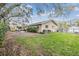 Lush backyard with a large lawn, brick patio, and mature shade trees at 217 2Nd Sw St, Largo, FL 33770