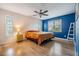 Bright bedroom with wood floors, a ceiling fan, and an accent wall with natural light at 217 2Nd Sw St, Largo, FL 33770