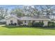 Well-maintained single-story home with a green lawn, complemented by mature trees and landscaping at 217 2Nd Sw St, Largo, FL 33770