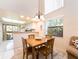 Bright dining area next to the kitchen features a wood table set for four and a modern chandelier at 226 Woodlake Wynde, Oldsmar, FL 34677