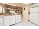 Kitchen features white appliances and cabinetry, plus granite countertops and views to the living room at 226 Woodlake Wynde, Oldsmar, FL 34677