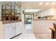 Bright kitchen area with white cabinets, granite countertops, and a decorative mirrored bar area at 226 Woodlake Wynde, Oldsmar, FL 34677