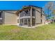 Condo backyard features a screened in patio, landscaping, and a grassy lawn at 226 Woodlake Wynde, Oldsmar, FL 34677