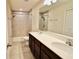Bright bathroom featuring a double sink vanity, large mirror, and a tiled walk-in shower at 3032 Inlet Breeze Way, Holiday, FL 34691