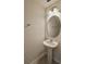 Simple powder room with a pedestal sink, oval mirror, and neutral wall color at 3032 Inlet Breeze Way, Holiday, FL 34691
