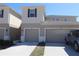 Charming two-story townhome features attached garages, neutral siding, and well-maintained landscaping at 3032 Inlet Breeze Way, Holiday, FL 34691