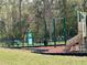 Community playground featuring swings, slides, and a playground area surrounded by woods at 3032 Inlet Breeze Way, Holiday, FL 34691
