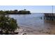 Scenic waterfront view with a pier, a boat, and a person wading in the water at 3032 Inlet Breeze Way, Holiday, FL 34691