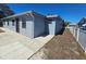 Exterior shot of the backyard showcasing the textured facade and hardscaped patio at 3136 Primrose Dr, Holiday, FL 34691