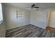 A simple bedroom has wood-look flooring, built in shelves, and fan at 3136 Primrose Dr, Holiday, FL 34691