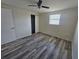 A simple bedroom has wood-look flooring, closet, and ceiling fan at 3136 Primrose Dr, Holiday, FL 34691
