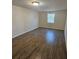 A simple bedroom features wood-look flooring and neutral walls at 3136 Primrose Dr, Holiday, FL 34691