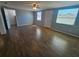 Bright living room with wood-look floors, neutral paint and natural light from two windows at 3136 Primrose Dr, Holiday, FL 34691