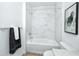 Bright bathroom featuring a shower-tub combo with modern fixtures and elegant marble-style tiling at 3402 E 28Th Ave # 7, Tampa, FL 33605