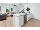Modern kitchen featuring white cabinets, stainless steel appliances, and an open layout into the living area at 3402 E 28Th Ave # 7, Tampa, FL 33605