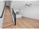 Open-concept living space with wood floors, modern ceiling fan, and staircase to upper level at 3402 E 28Th Ave # 7, Tampa, FL 33605