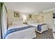 Comfortable bedroom with two queen beds, bedside table, dresser, and serene decor for relaxation at 36750 Us Highway 19 N # 01205, Palm Harbor, FL 34684